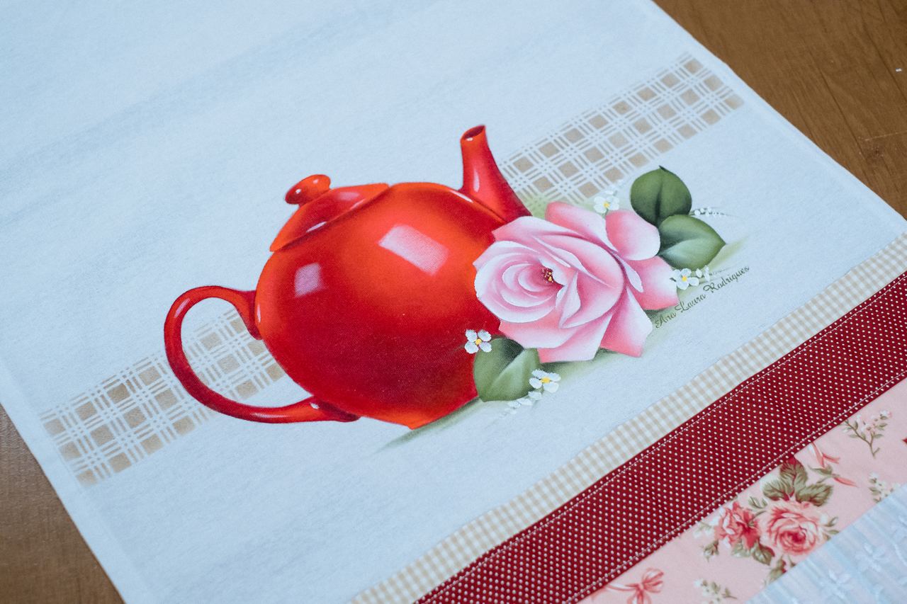 Bule vermelho com rosa cor-de-rosa pintado à mão em pano de prato